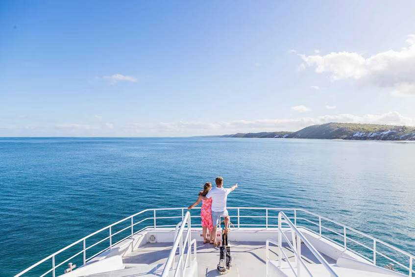 People standing on the front of a tour boat around K'Gari
