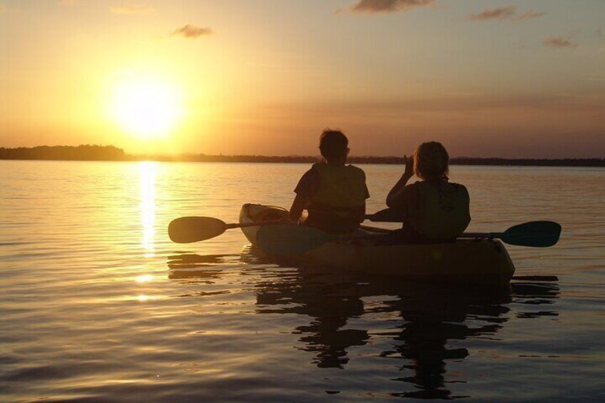 people in kayak at sunset