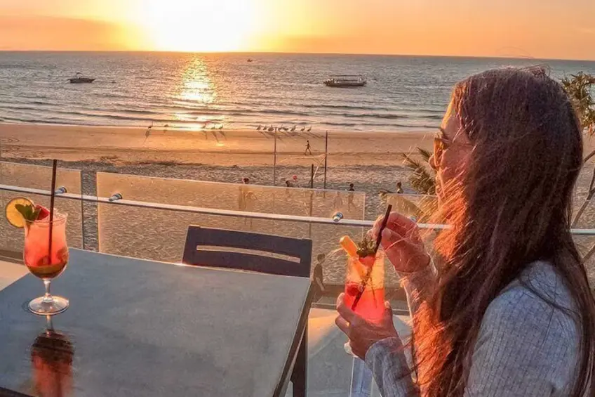 person having a drink on Moreton Island at sunset